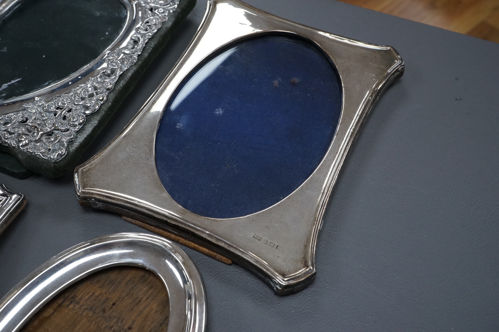 Four assorted early 20th century silver mounted photograph frames, the largest with pierced decoration, Chester, 1902, 19.5cm.